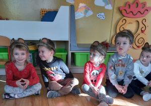 Dzieci siedzą w misiowych opaskach z uszami